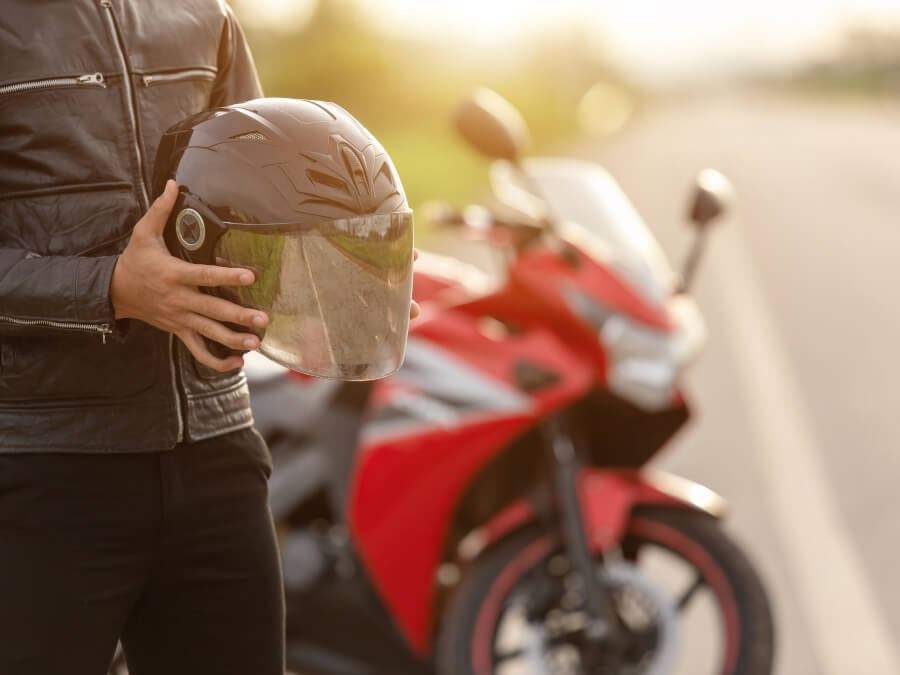 ヘルメットを持つライダーとバイク